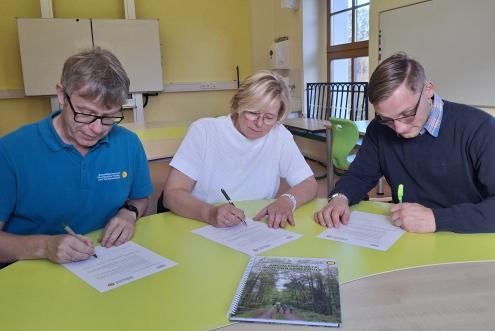 Torsten Roch (Leiter der Biosphärenreservatsverwaltung), Kerstin Wilke (Schulleiterin) und Henrik Biehle (Bürgermeister Gemeinde Hohendubrau) unterschreiben die Kooperationsvereinbarung für drei weitere Jahre Biosphärenschule (Foto: Jennifer Otto)